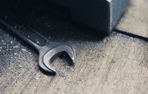 金属の切粉とスパナが散らばる工作台での作業風景