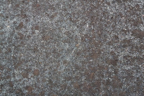 小さな石や砂が埋め込まれた灰色のアスファルト地面のテクスチャー