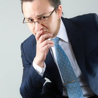 困った顔をする外資系の男性会社員の写真