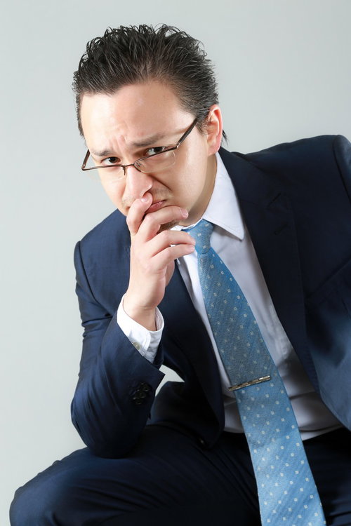 困った顔をする外資系の男性会社員