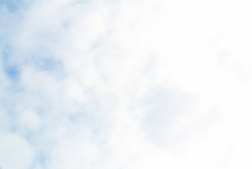 白い雲が広がる晴れた昼間の空を見上げた写真