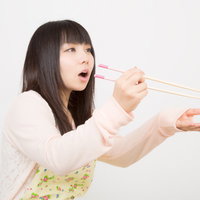 「あーん！」っと味見をさせるエプロン姿の妻の写真