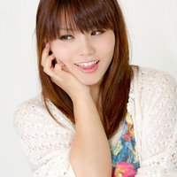 手を添えて微笑む女性のポートレートの写真