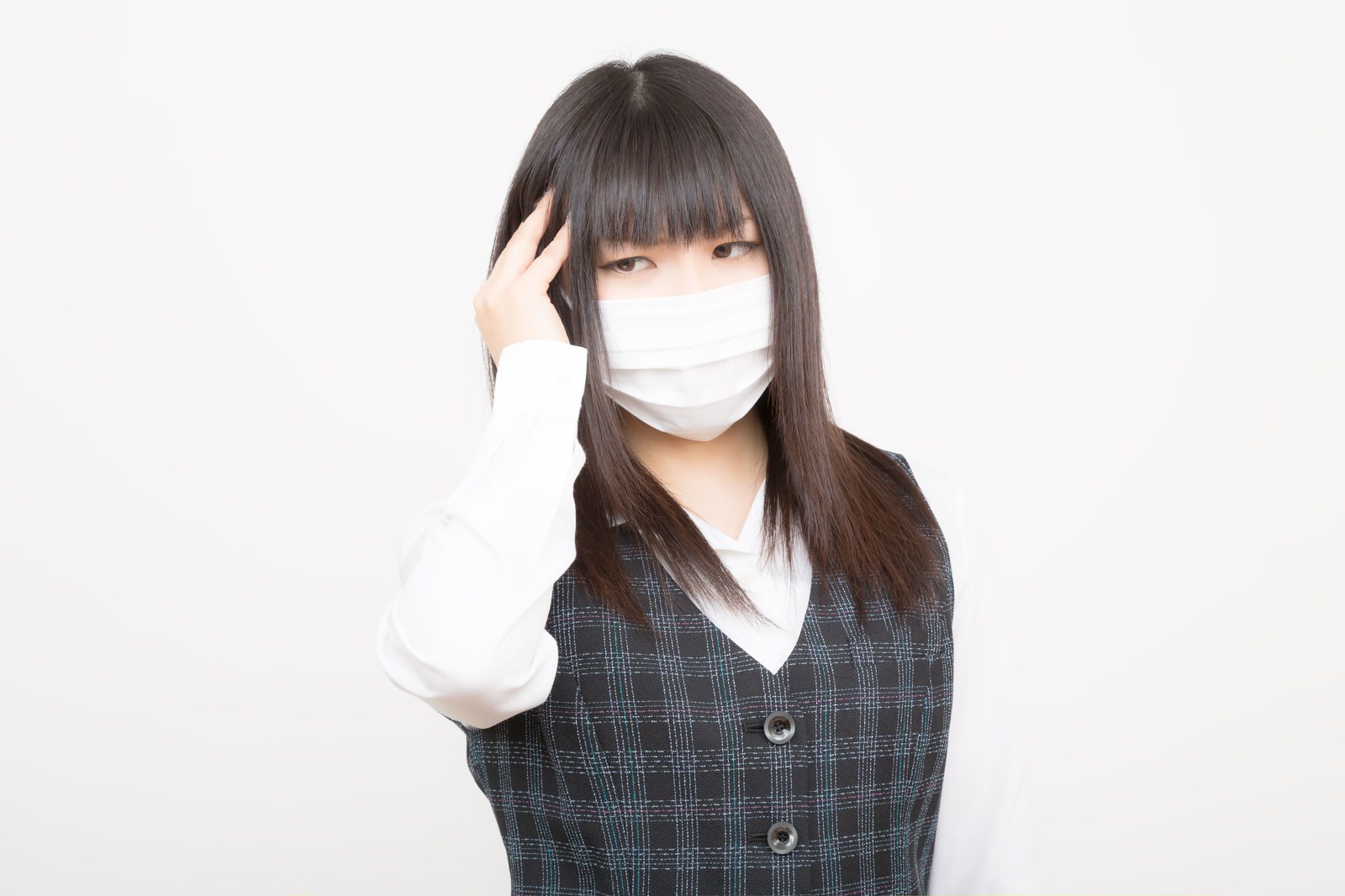 マスクをして頭を押さえる女性［モデル：Lala］