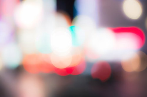 夜の暗い空間にぼけた光の粒や線が浮かぶピンぼけの繁華街写真