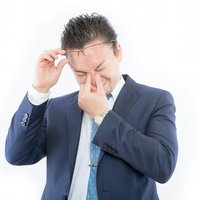 感極まって目頭が熱くなるスーツ姿の外国人の写真