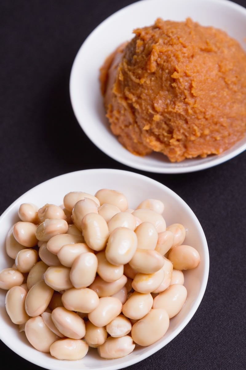 白い皿に盛られた味噌と大豆