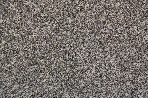 グレーのアスファルトに広がるまだら模様のテクスチャー