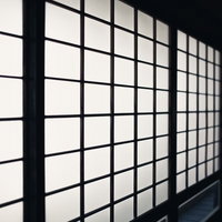 黒い木枠に白い半透明の紙が光を通す和室の障子の写真