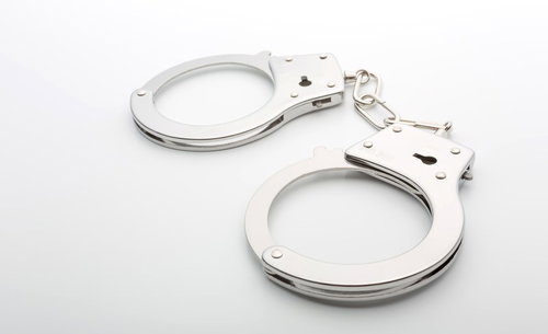 白背景に置かれた銀色の手錠と鍵