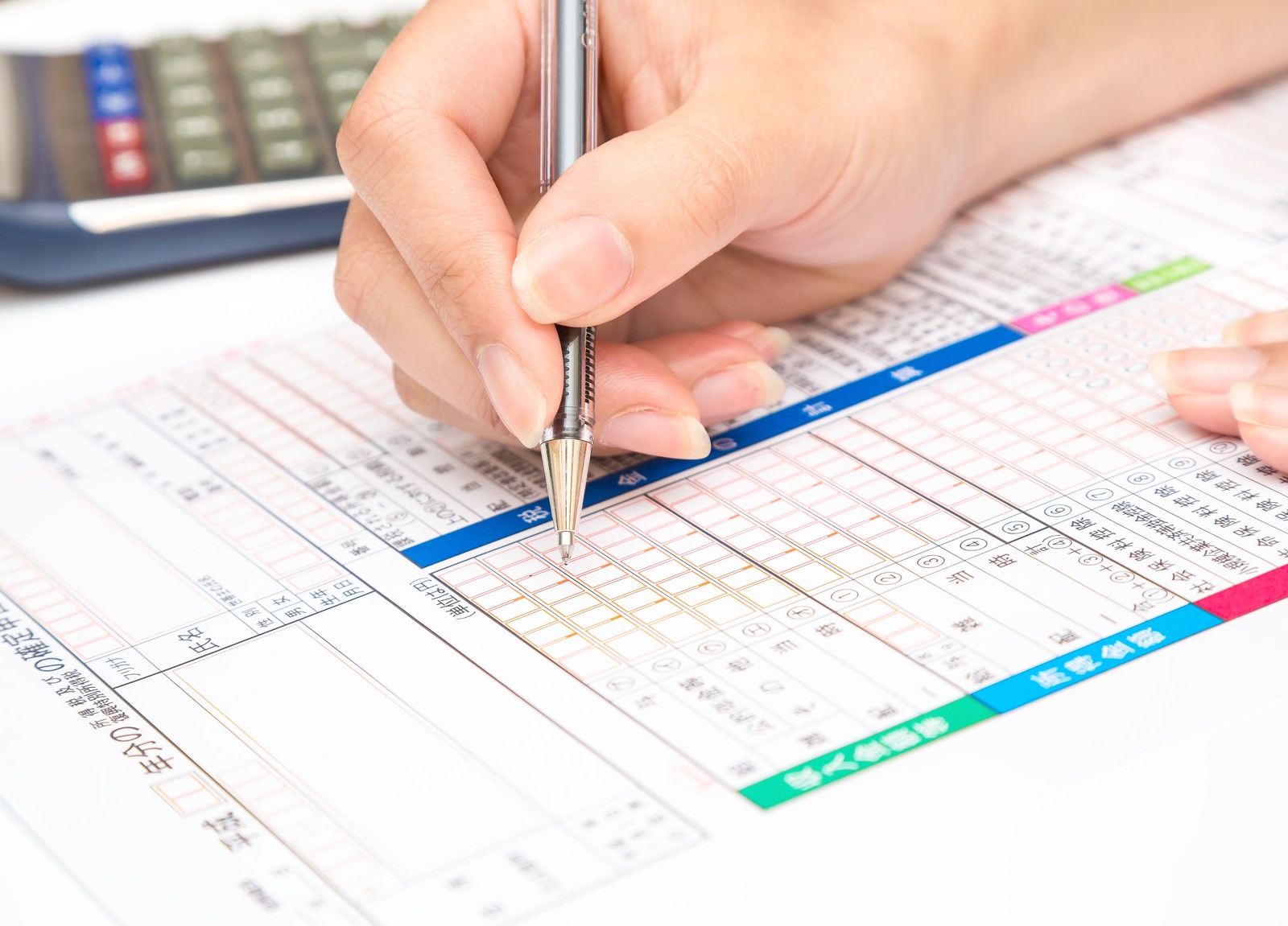 確定申告書にボールペンで記入する手元