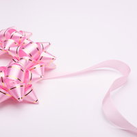 白い面に置かれたピンクのラッピングリボンの写真