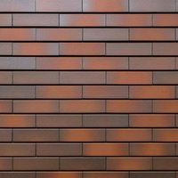 茶色やオレンジや灰色が混じるレンガ模様タイルの壁テクスチャーの写真