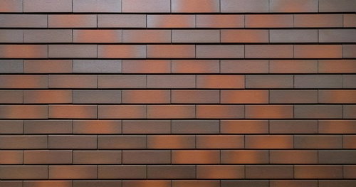 茶色やオレンジや灰色が混じるレンガ模様タイルの壁テクスチャー
