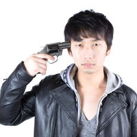 拳銃を頭に向ける革ジャケットの男性の写真