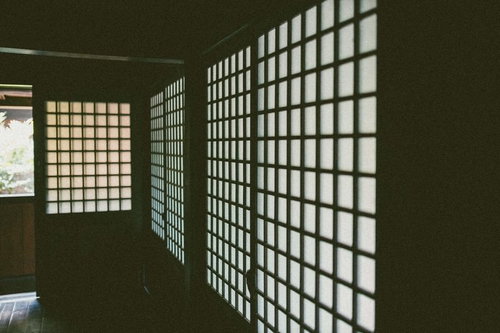 半透明の白い紙が貼られた和室の格子状の障子が並ぶ廊下