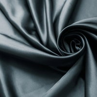 渦巻き状にねじれた光沢のある灰色のサテン生地のテクスチャーの写真