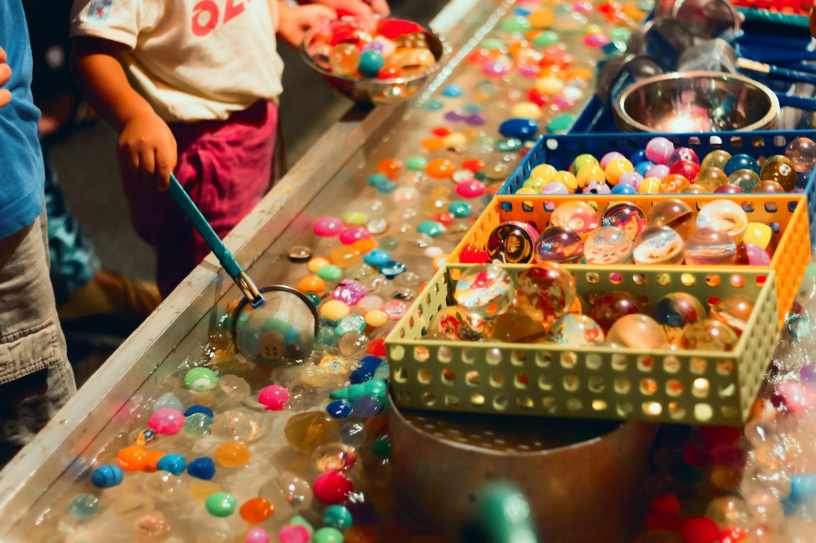 出店のスーパーボールすくいで遊ぶ子供の手元