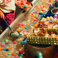 出店のスーパーボールすくいで遊ぶ子供の写真