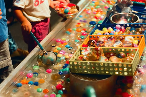 出店のスーパーボールすくいで遊ぶ子供