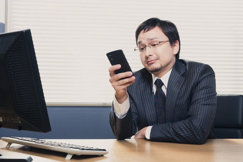 スマホの内容に困惑するサラリーマン