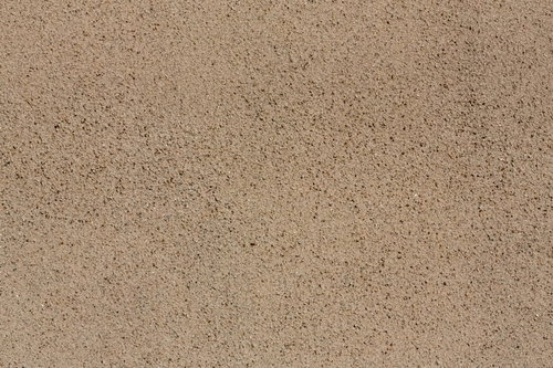 細かい砂粒が均一に広がるベージュ色の砂壁テクスチャ