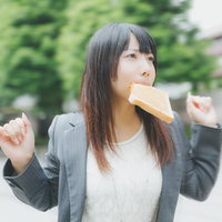 トーストを咥えて走る女性社員の写真