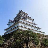 石垣の上に建つ鶴ヶ城と青空の写真