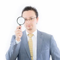 虫眼鏡で調査するドイツ人ハーフのビジネスマンの写真