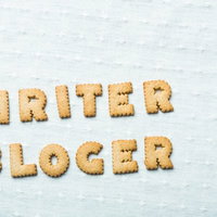 水色の木目調にWRITERとBLOGERと並べたアルファベットクッキーの写真