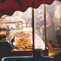 赤い屋根の夜の屋台で串焼き肉を焼く焼き鳥の露店の写真