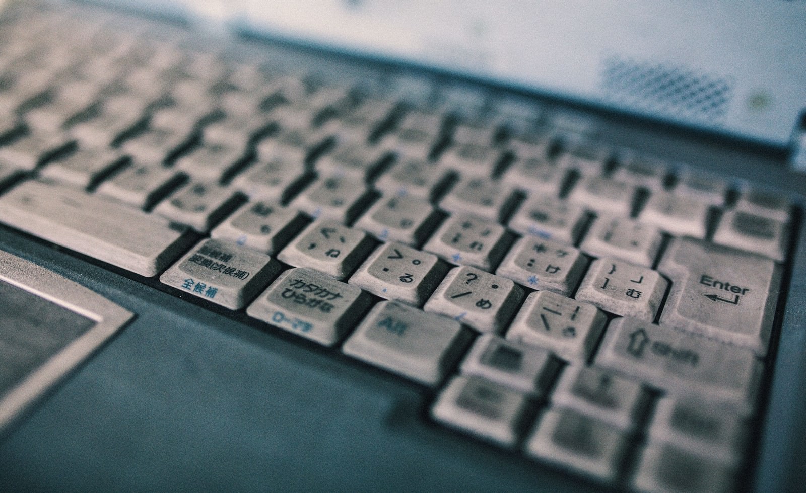 日本語キーが印字された汚れたノートパソコンのキーボード