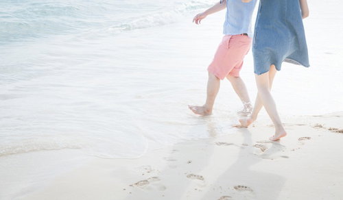 宮古島の波打ち際ではしゃぐカップルが夏のデート中