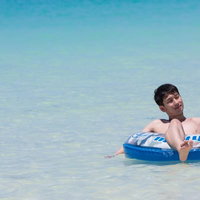 安心してください、穿いてますよ〜宮古島の海で浮き輪に乗る男性の写真