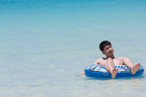 安心してください、穿いてますよ〜宮古島の海で浮き輪に乗る男性