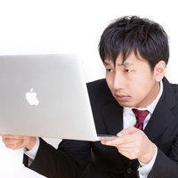 マックブックを覗きこむサラリーマンの写真