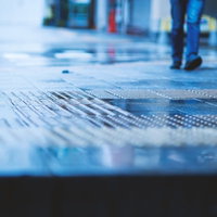 雨に濡れた駅のホームと点字ブロックの写真