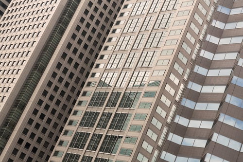 青空を背景に見上げた高層オフィスビル群