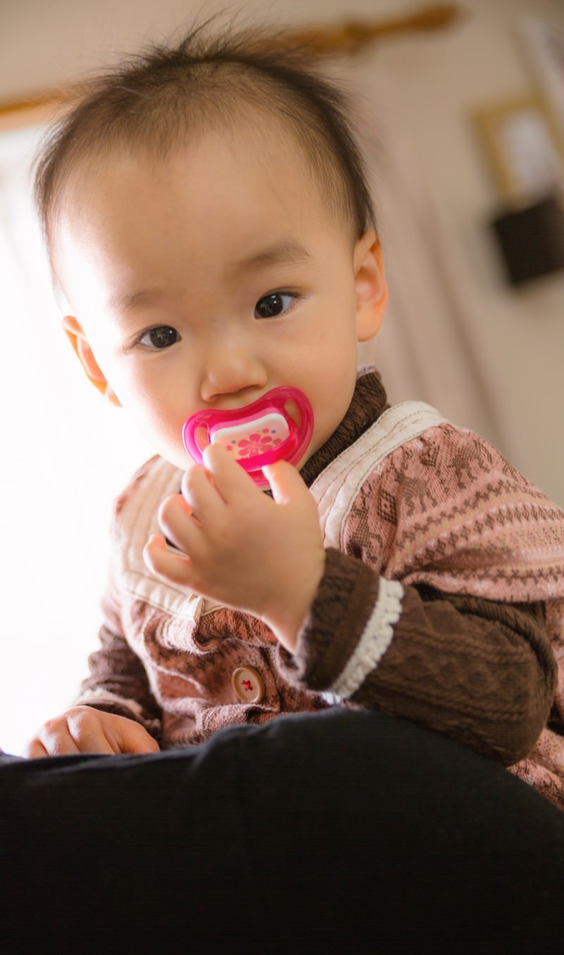 おしゃぶりを咥えて抱っこされる赤ちゃん［モデル：あんじゅ］