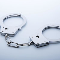 白い面に置かれた銀色の手錠の写真