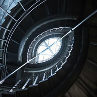 窓から光が差し込む螺旋階段の吹き抜けの写真