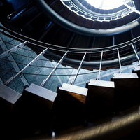 下から見上げた白い螺旋階段と光の写真