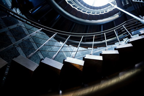 下から見上げた白い螺旋階段と光