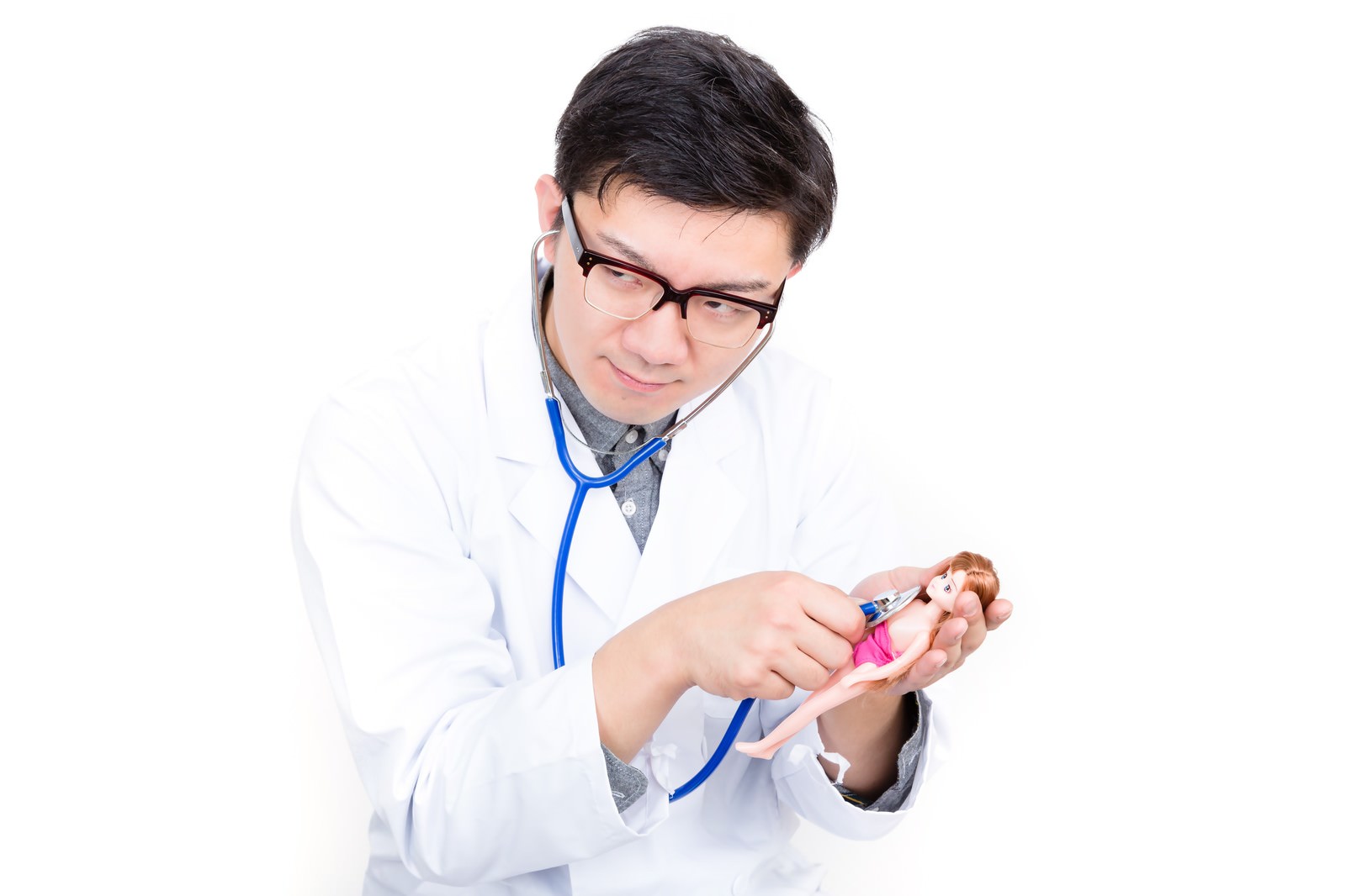 ピンクの豚の置き物に聴診器を当てるお医者さんごっこの男性［モデル：OZPA］