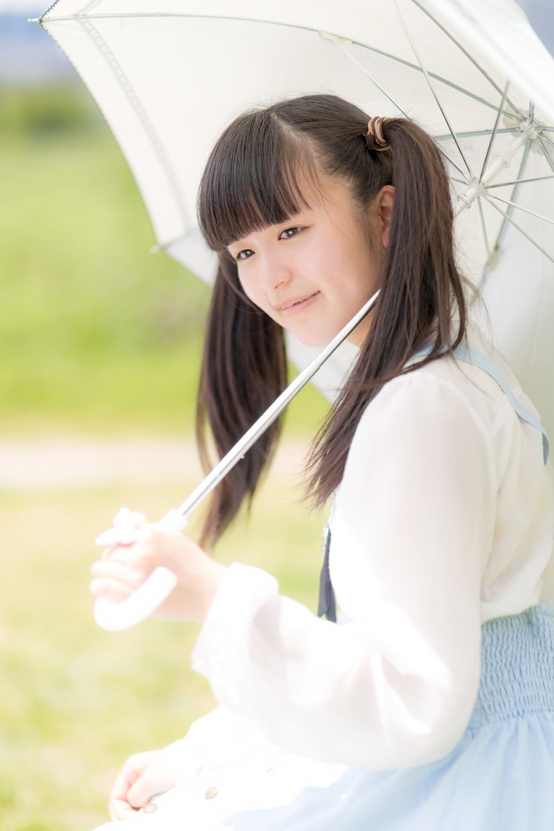 白い傘をさして屋外に立つツインテールの女の子［モデル：こころ］