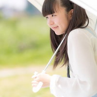 日傘をさしたツインテール姿の女の子、白いシャツの写真