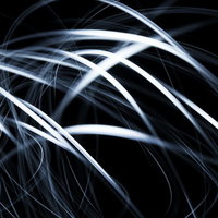 真っ黒な背景に白い光跡が重なり模様を描く長時間露光写真の写真