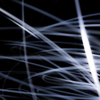 白や灰色の細い線が交差して浮かぶ光の軌跡の写真