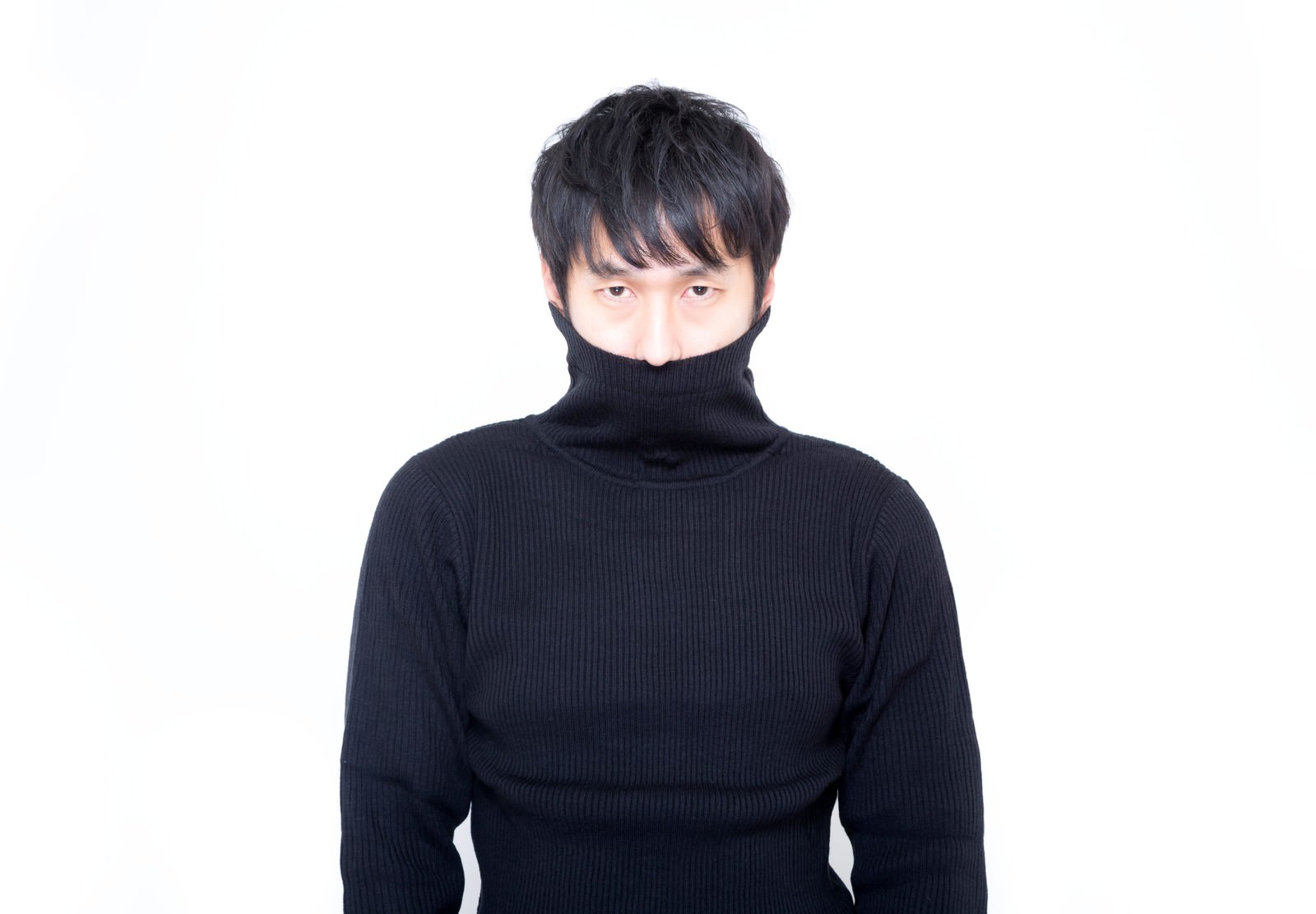 黒い縦線タートルネックの首元を引き上げて口元を隠す男性［モデル：大川竜弥］
