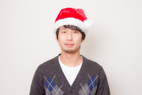 サンタ帽をかぶったカーディガン姿の男性